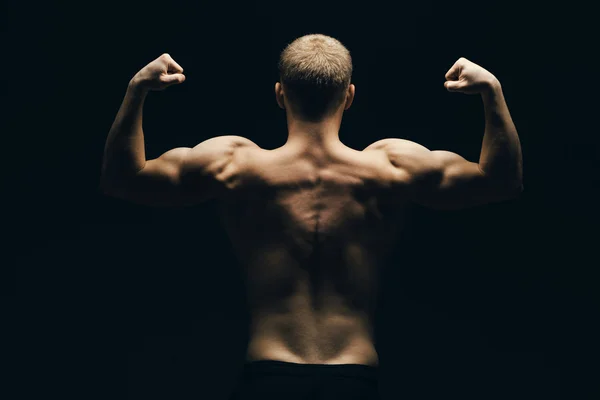 Крупним планом спортивний чоловік м'язистий ізольований на чорному тлі — стокове фото