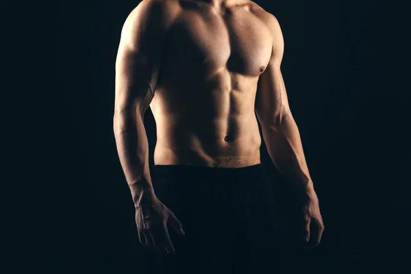 Крупним планом спортивний чоловік м'язистий ізольований на чорному тлі — стокове фото