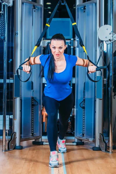 Młoda atrakcyjna kobieta szkolenia taśmą htrx fitness Studio sale gimnastyczne — Zdjęcie stockowe