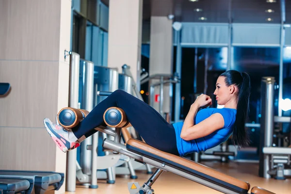 Hermosa mujer haciendo ejercicio de ejercicio de prensa en el gimnasio deportivo . — Foto de Stock