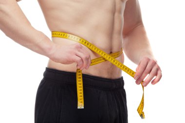 Atletik genç adam onun vücut kemer ölçme.