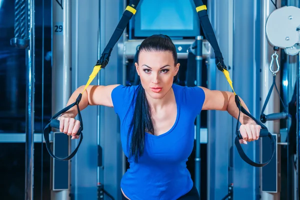 TRX. fitness, sport, träning, teknik och människor koncept - leende ung kvinna gör övning i gymmet. — Stockfoto