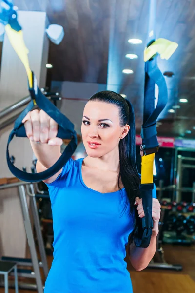 TRX. fitness, deportes, ejercicio, tecnología y conceptos de personas - mujer joven sonriente haciendo ejercicio en el gimnasio . — Foto de Stock