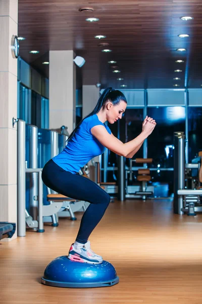 Ung kvinna utför steg aerobics övningar i gymmet. — Stockfoto