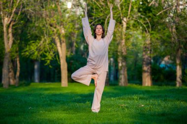 Ağaçlar arka plan ile sabah Yoga uygulamak