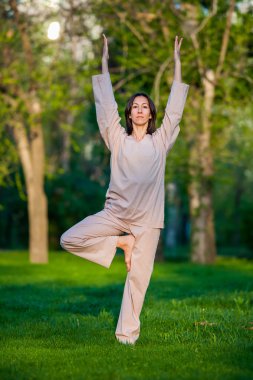 Ağaçlar arka plan ile sabah Yoga uygulamak