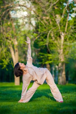 Ağaçlar arka plan ile sabah Yoga uygulamak