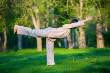 Ağaçlar arka plan ile sabah Yoga uygulamak