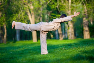 Ağaçlar arka plan ile sabah Yoga uygulamak