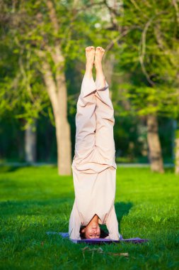 Ağaçlar arka plan ile sabah Yoga uygulamak