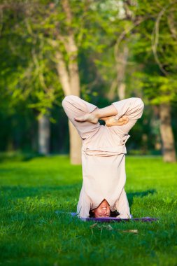 Ağaçlar arka plan ile sabah Yoga uygulamak