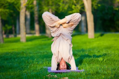 Ağaçlar arka plan ile sabah Yoga uygulamak