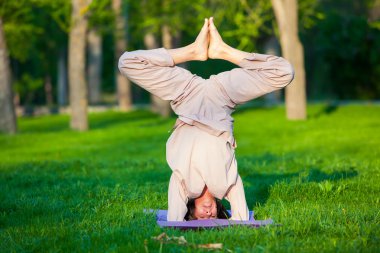 Ağaçlar arka plan ile sabah Yoga uygulamak