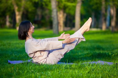 Ağaçlar arka plan ile sabah Yoga uygulamak