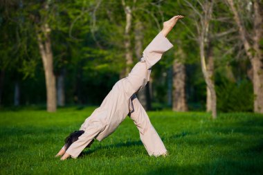 Ağaçlar arka plan ile sabah Yoga uygulamak