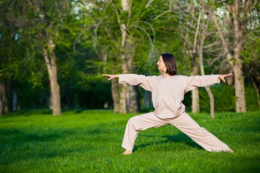 Ağaçlar arka plan ile sabah Yoga uygulamak