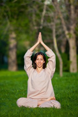 Ağaçlar arka plan ile sabah Yoga uygulamak