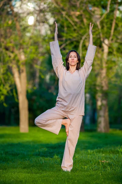 Öva yoga på morgonen, med träd bakgrund — Stockfoto