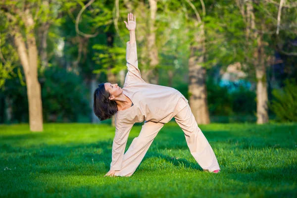 Practicar yoga por la mañana, con fondo de árboles — Foto de Stock