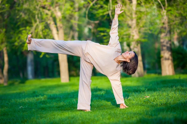 Pratiquer le yoga le matin, avec le fond des arbres — Photo