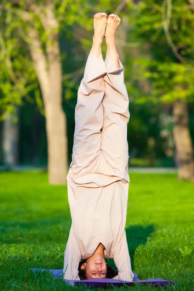 Практика йоги по утрам, с деревьями на заднем плане — стоковое фото