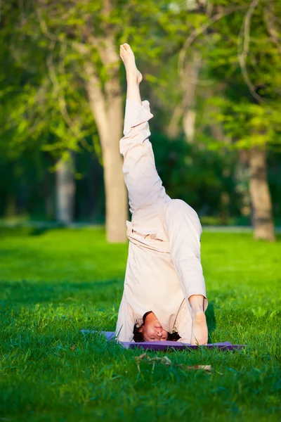 Praktykowanie jogi w godzinach porannych, w tle drzewa — Zdjęcie stockowe