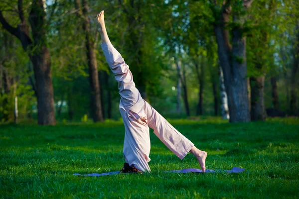 Practicing yoga in the morning, with trees  background — Stock Photo, Image