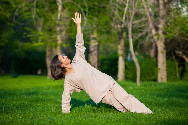 Практика йоги по утрам, с деревьями на заднем плане — стоковое фото