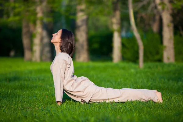 Praktykowanie jogi w godzinach porannych, w tle drzewa — Zdjęcie stockowe