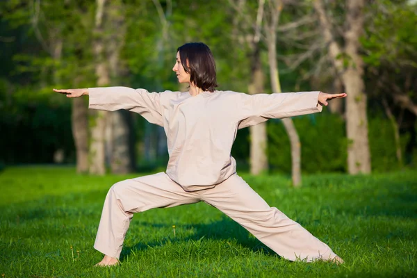 Practicar yoga por la mañana, con fondo de árboles — Foto de Stock
