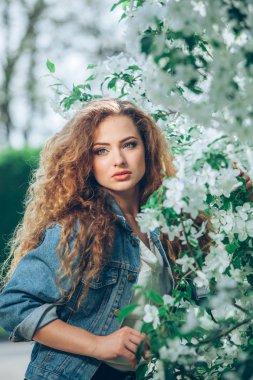 Açık havada kıvırcık saçlı güzel beyaz bir kız.