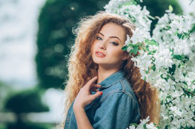 Açık havada kıvırcık saçlı güzel beyaz bir kız.