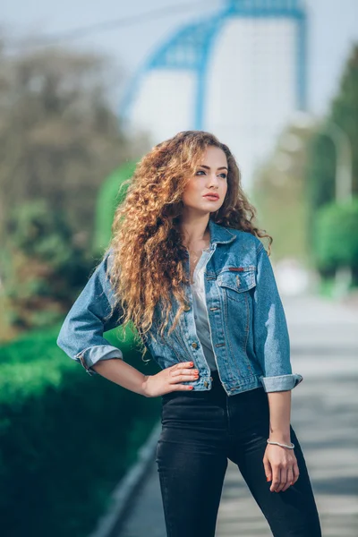 Красивая молодая кавказская девушка с вьющимися волосами на улице — стоковое фото