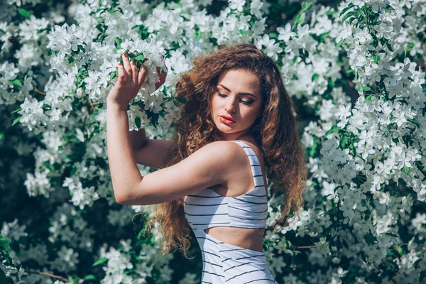 Beautiful young woman with gorgeous curly fair outdoors,flowering — Stock Photo, Image