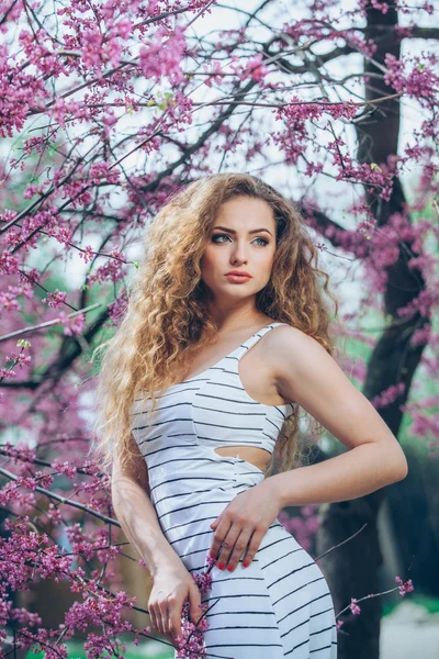 Beautiful young woman with gorgeous curly fair outdoors,flowering — Stock Photo, Image