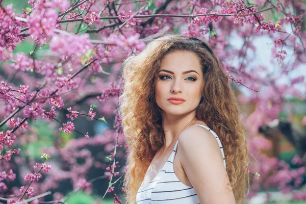 Beautiful young woman with gorgeous curly fair outdoors,flowering — Stock Photo, Image