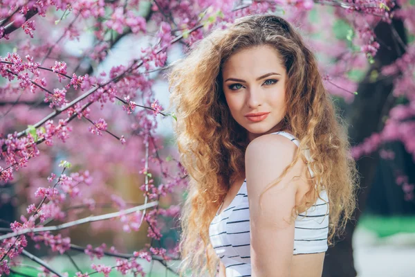 Hermosa mujer joven con hermosa feria rizada al aire libre, la floración — Foto de Stock