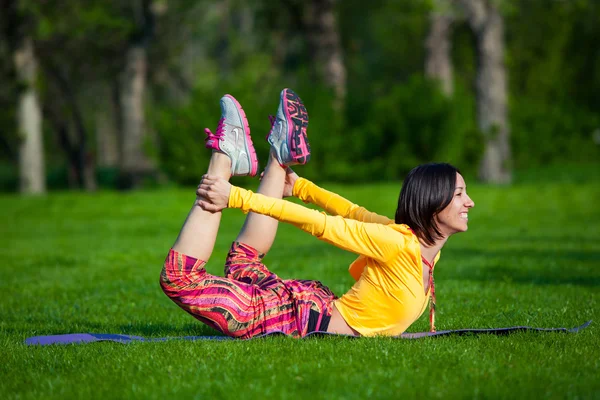 Bella donna che fa esercizi di yoga nel parco — Foto Stock