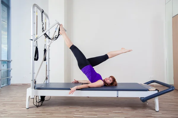 Gimnasio mujer pilato instructor estiramiento en reformador cama — Foto de Stock