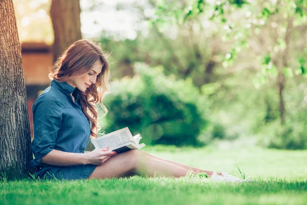 Dívka čtoucí knihu v parku — Stock fotografie