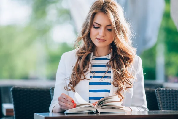 Bela jovem no café ao ar livre lendo um livro e beber café. Telefone. Estudante. mulher de negócios — Fotografia de Stock