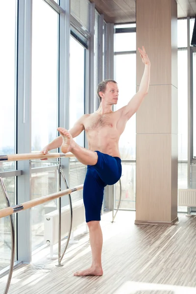 In the hall man doing stretching near Barre. — Stock Photo, Image