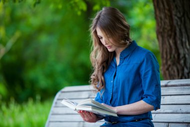 Kız parkta bir kitap okuma