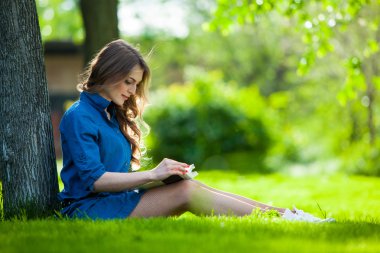 Kız parkta bir kitap okuma