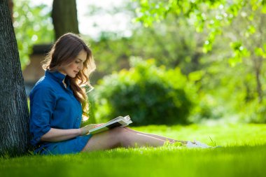 Kız parkta bir kitap okuma