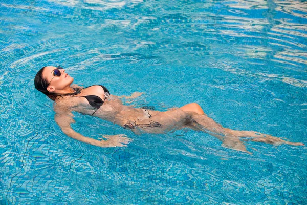 Sexy swimmer. A slender sexy lady in bikini balancing on her bac — Stock Photo, Image