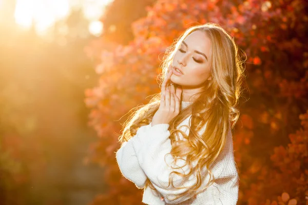 Mujer joven sobre un fondo de hojas de otoño rojas y amarillas con hermoso pelo rizado —  Fotos de Stock