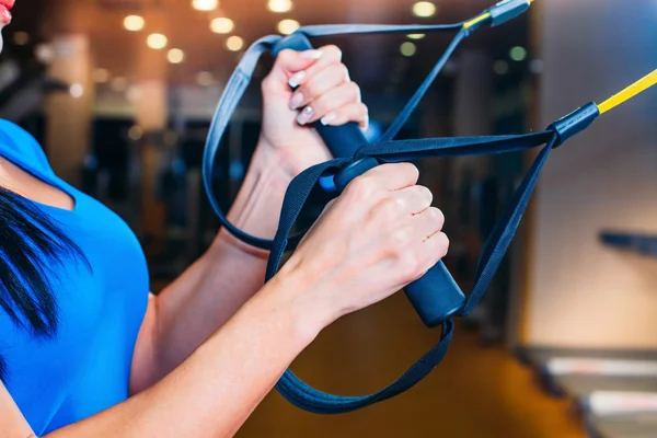 Jovem mulher atraente treinamento com tiras de fitness htrx no — Fotografia de Stock