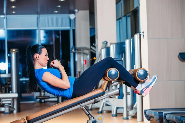 Hermosa mujer haciendo ejercicio de ejercicio de prensa en el gimnasio deportivo . — Foto de Stock