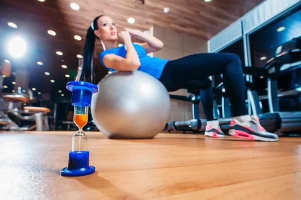 Tjej som tränar på gym med en boll, i förgrunden av en ho — Stockfoto